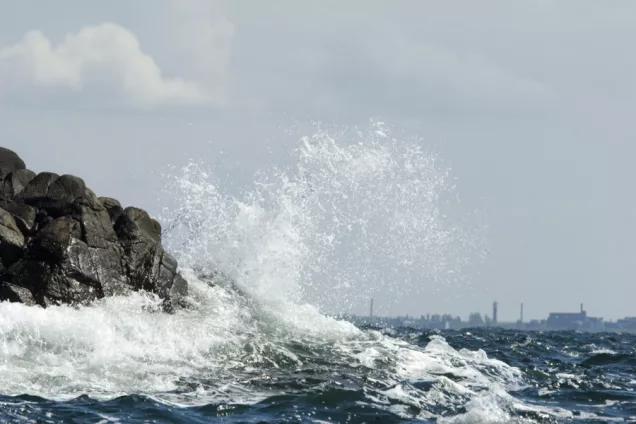 Havsvåg som slår upp mot en klippa. Foto.
